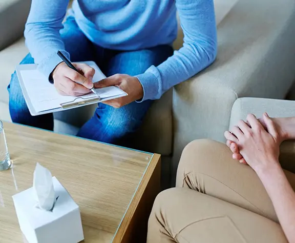 Male Psychologist Making Notes During Psychological Therapy